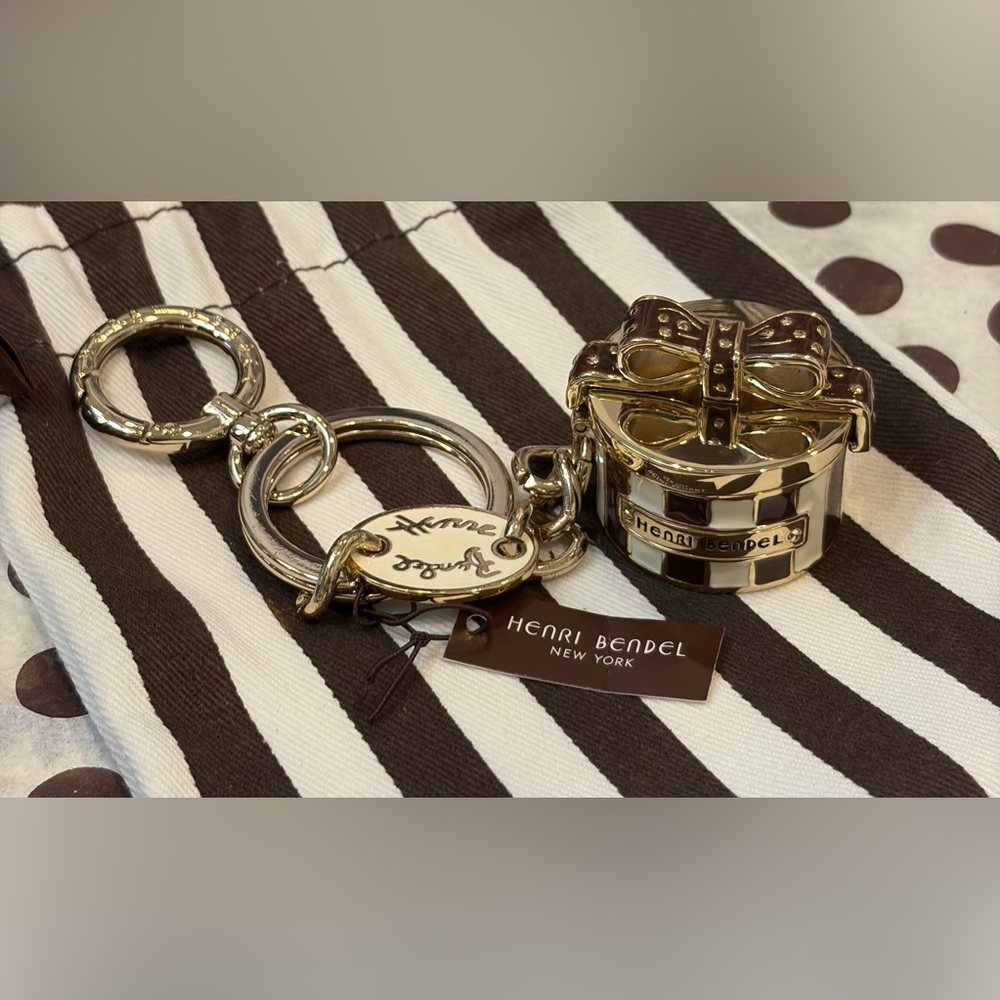 NWT HENRI BENDEL Gold Keychain and/or bag charm. Opens & snap closure.